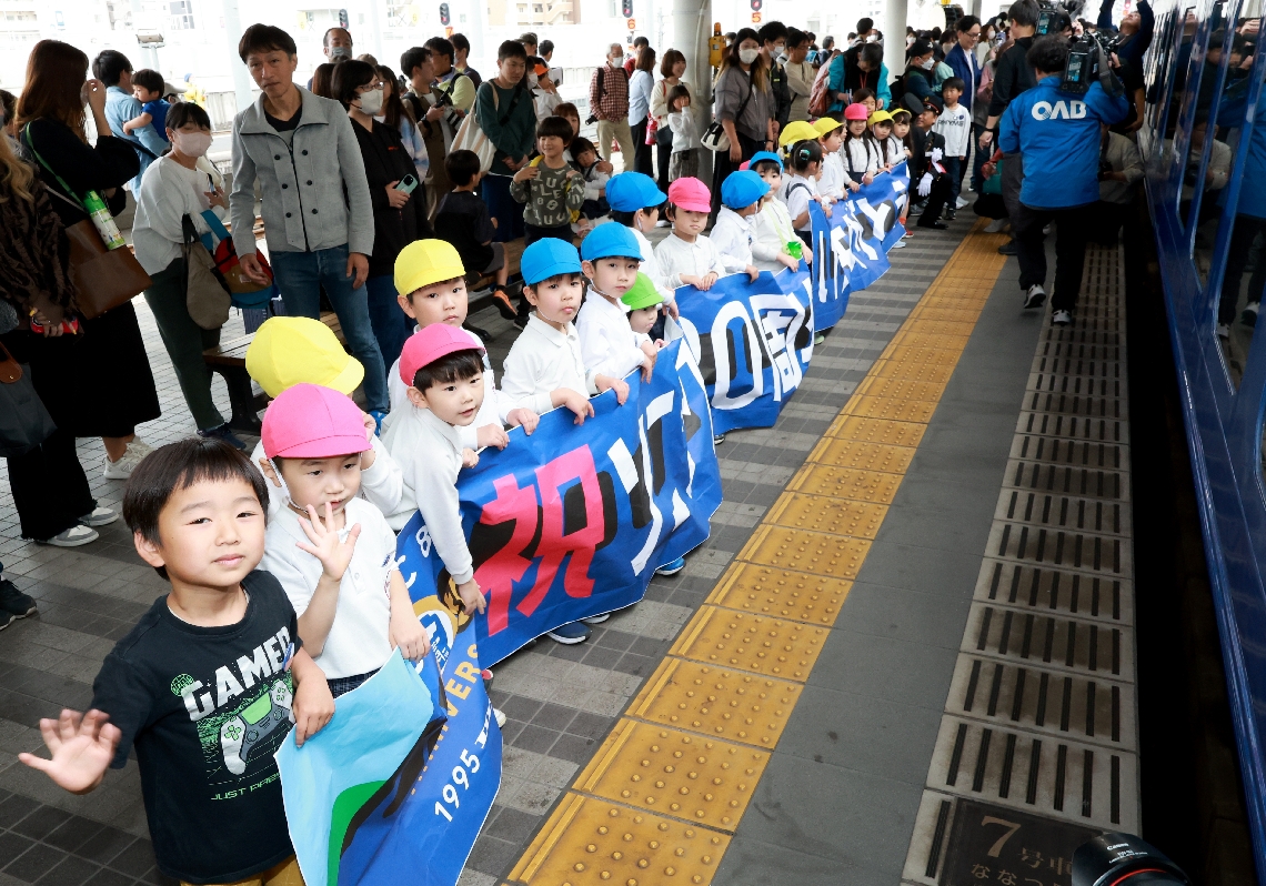 「ソニック３０周年おめでとう」などと記した横幕で祝うルナ幼稚園の園児
