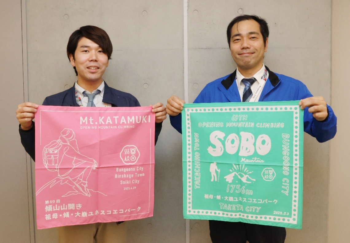 記念バンダナを手に「アケボノツツジや新緑を楽しんで」と話す豊後大野市商工観光課の職員＝豊後大野市