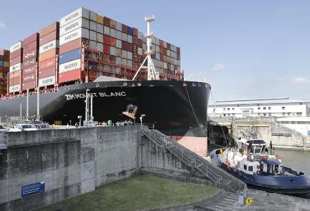 パナマ運河の水門を通過するコンテナ船＝１月、パナマの首都パナマ市近郊（共同）