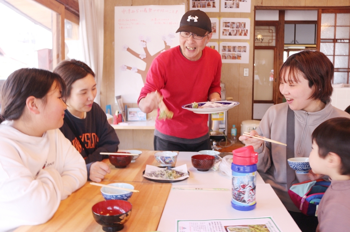 交流ハウスのカフェで開かれたワークショップに参加し、タラの芽の天ぷらを楽しむ人たち