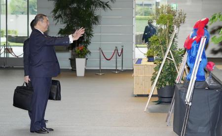 首相官邸に入り、大阪・関西万博の公式キャラクター「ミャクミャク」の人形に手を振る石破首相＝４月