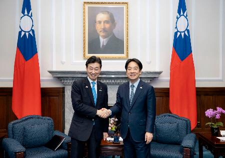 ５日、台北市の総統府で台湾の頼清徳総統（右）と握手する西村元経産相（総統府提供・共同）
