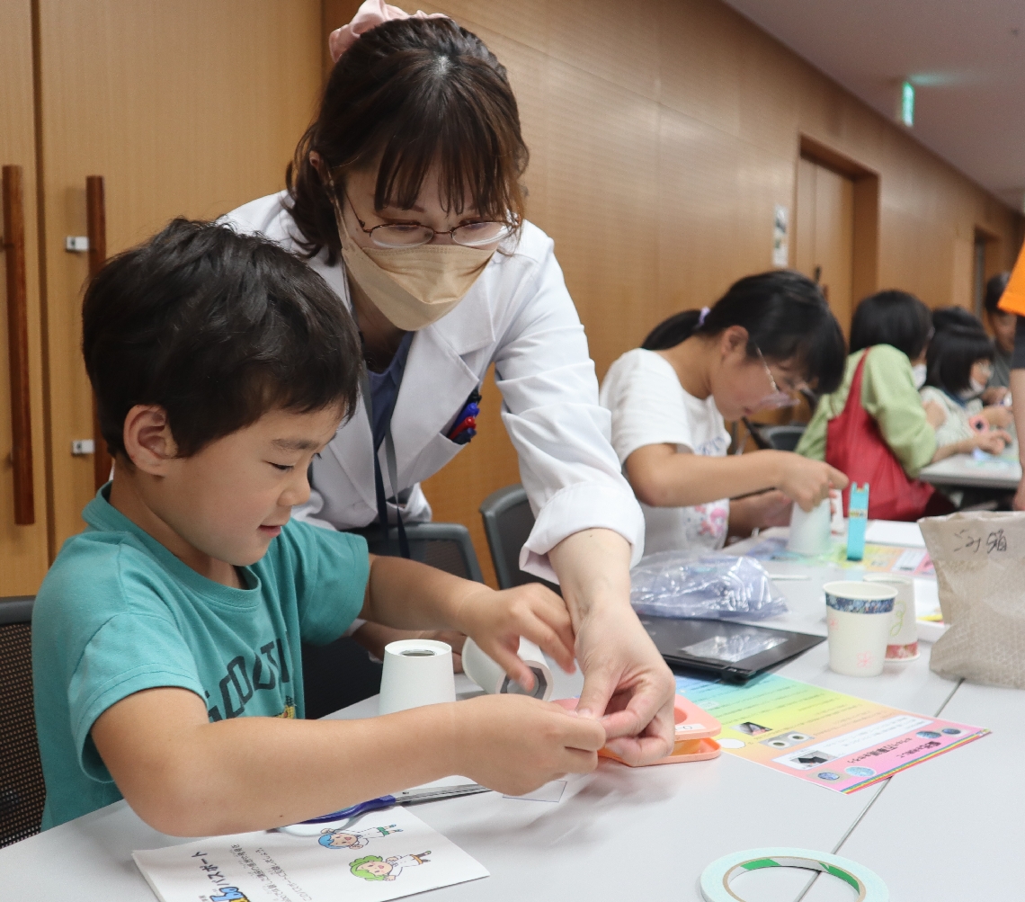 紙コップを使った万華鏡作りに取り組む児童ら＝１０日、大分市金池南のホルトホール大分