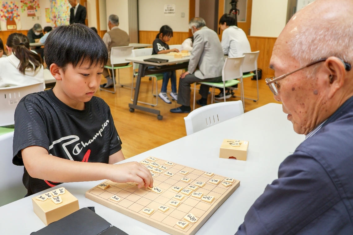 講師の地元住民（右）との対局を楽しむ児童＝宇佐市岩崎の北馬城小