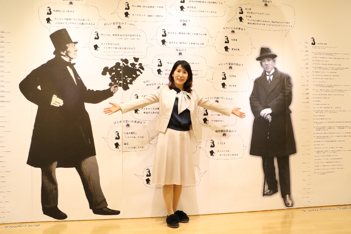 アンデルセン（左）と久留島武彦（右）の等身大写真を背に「２人の歩みを知って」と呼びかける金成妍館長＝玖珠町森の久留島武彦記念館