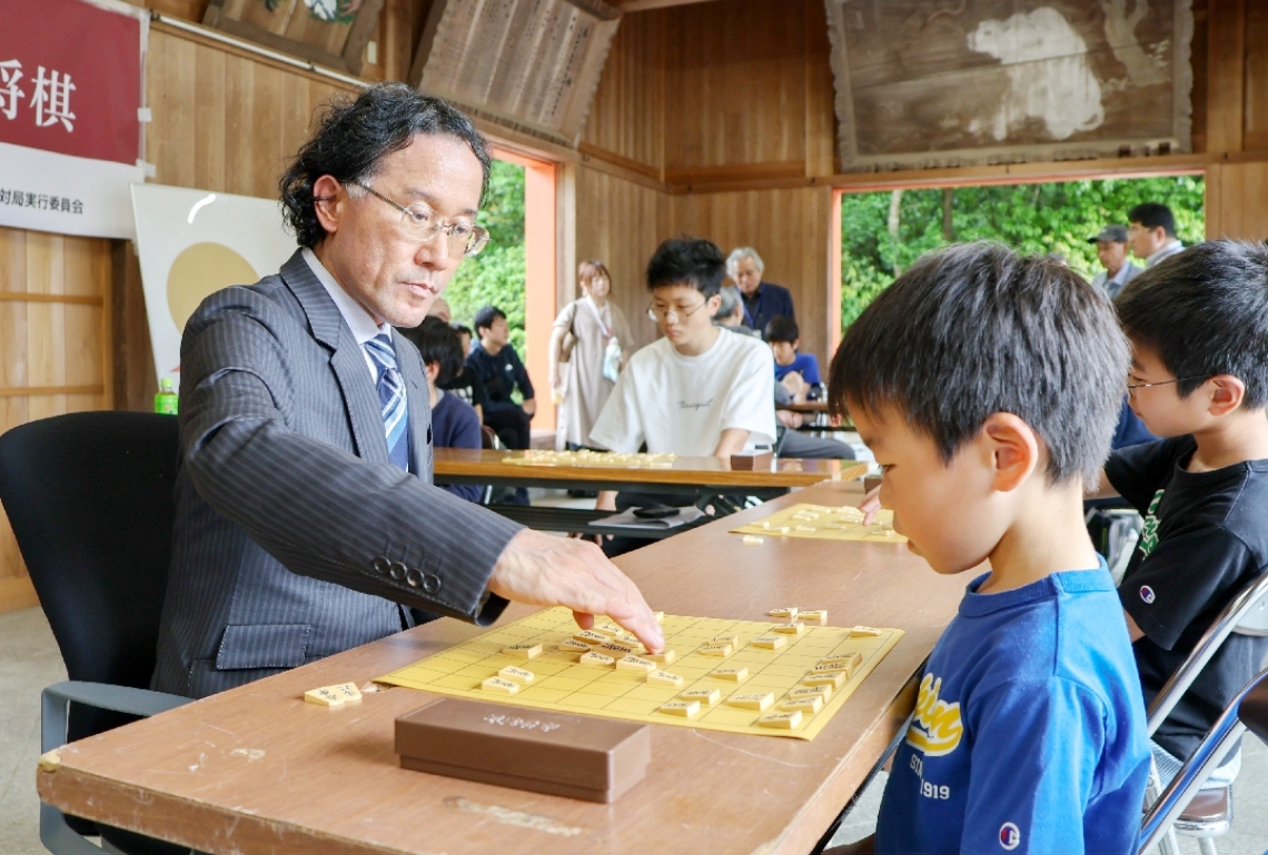 深浦康市九段との真剣勝負に挑む子どもたち＝宇佐市の宇佐神宮絵馬殿
