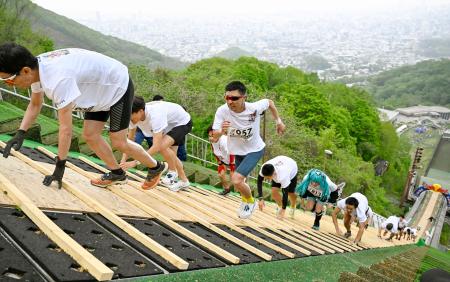 札幌市の大倉山ジャンプ競技場で、ラージヒルを駆け上がる参加者＝１７日午前