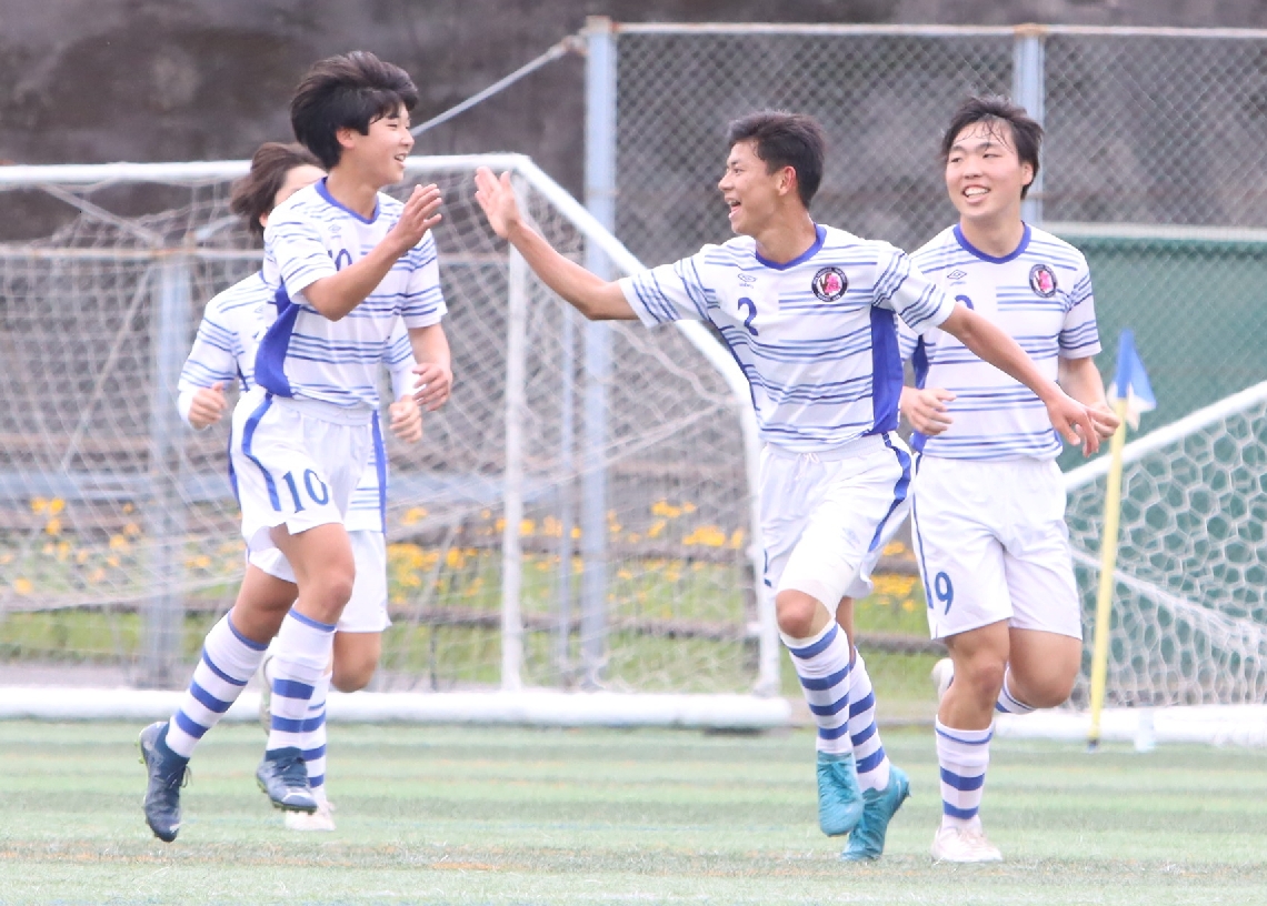 【男子２回戦・玖珠美山―楊志館】先制点を決めて喜ぶ楊志館の選手たち＝佐伯市総合運動公園