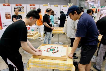 滋賀県の郷土ゲーム「カロム」を楽しむ人たち＝１８日午前、千葉市の幕張メッセ