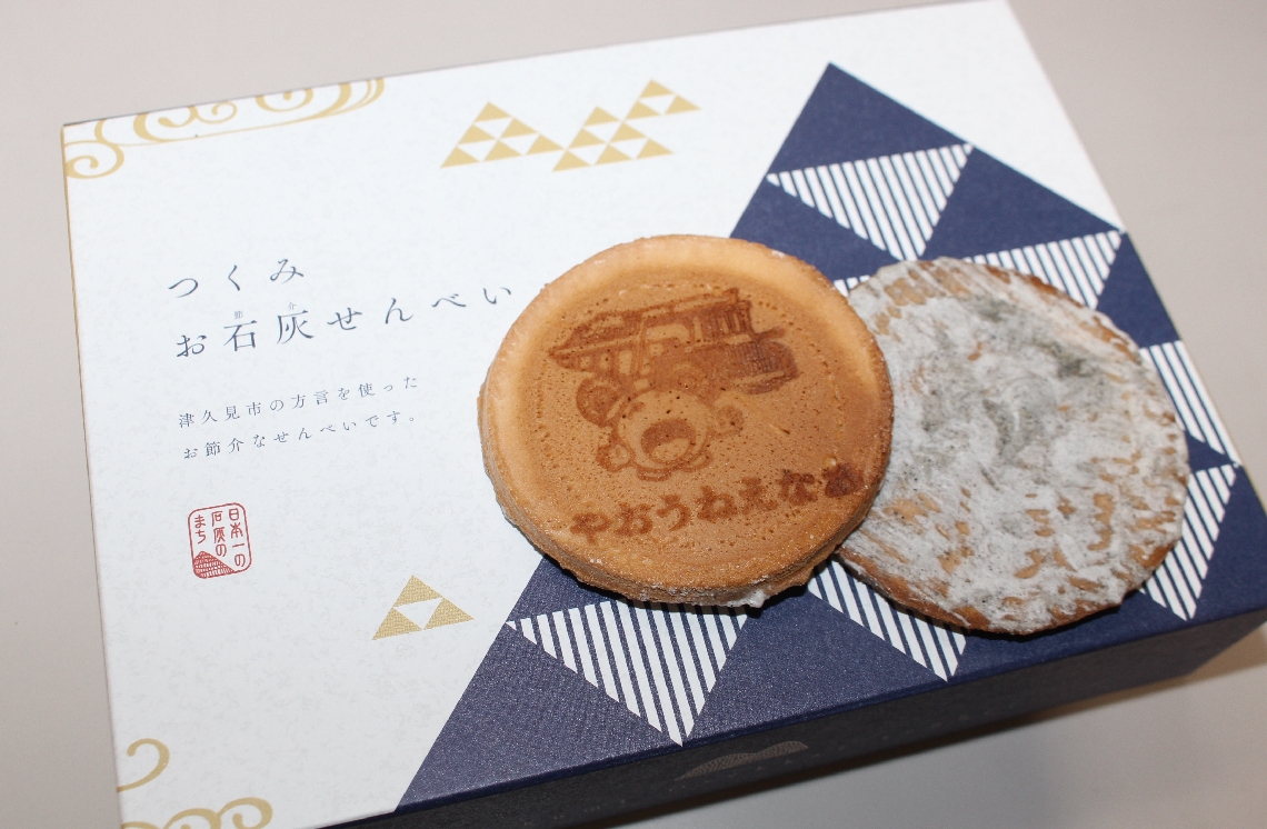 せんべいの表面にはお節介な方言の焼き印。裏面は石灰をイメージした灰色の糖衣で覆われている