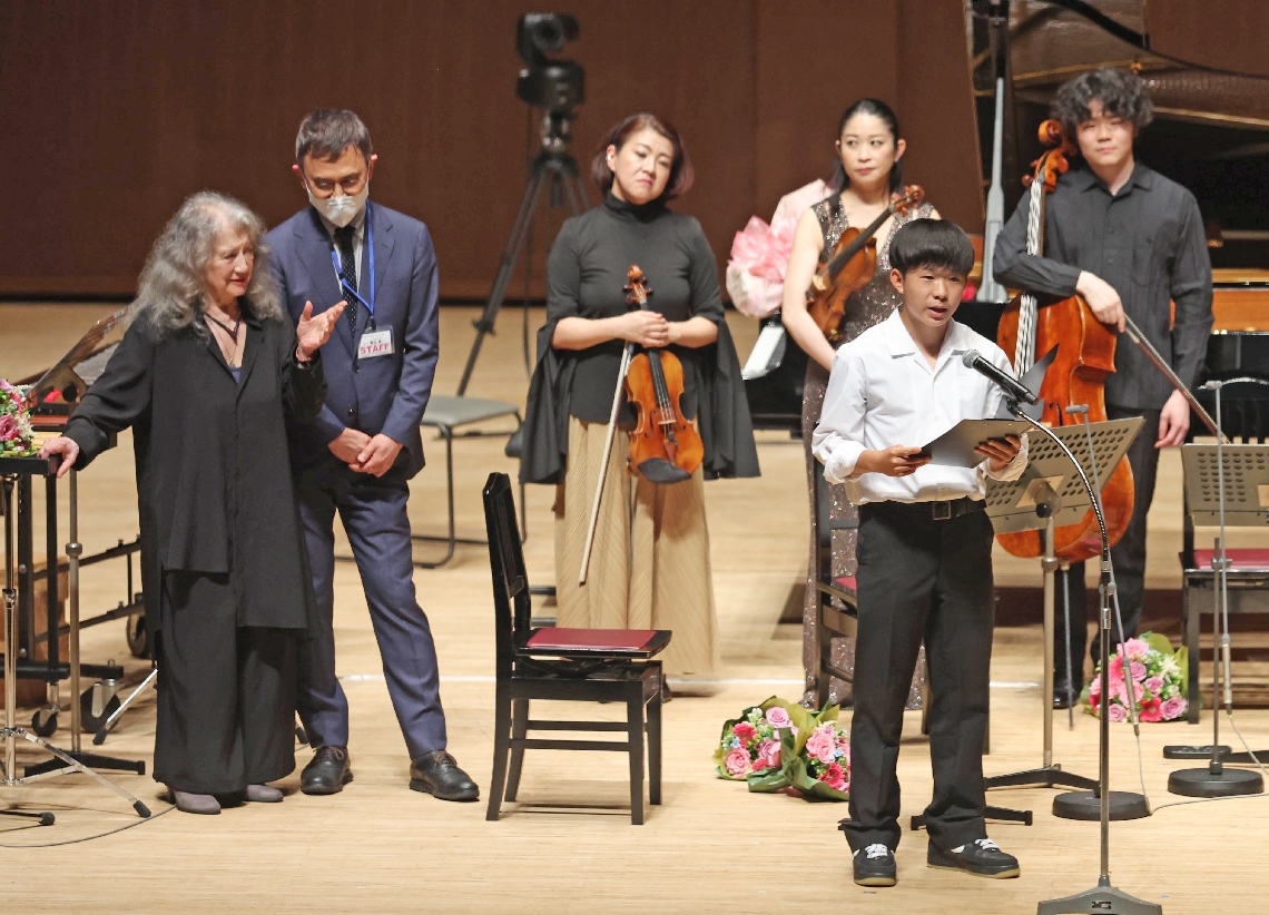 平和実現への決意を述べる花崎太智さん（右・宇佐高３年）とメッセージを送ったマルタ・アルゲリッチ総監督（左）＝２１日、大分市高砂町のいいちこグランシアタ