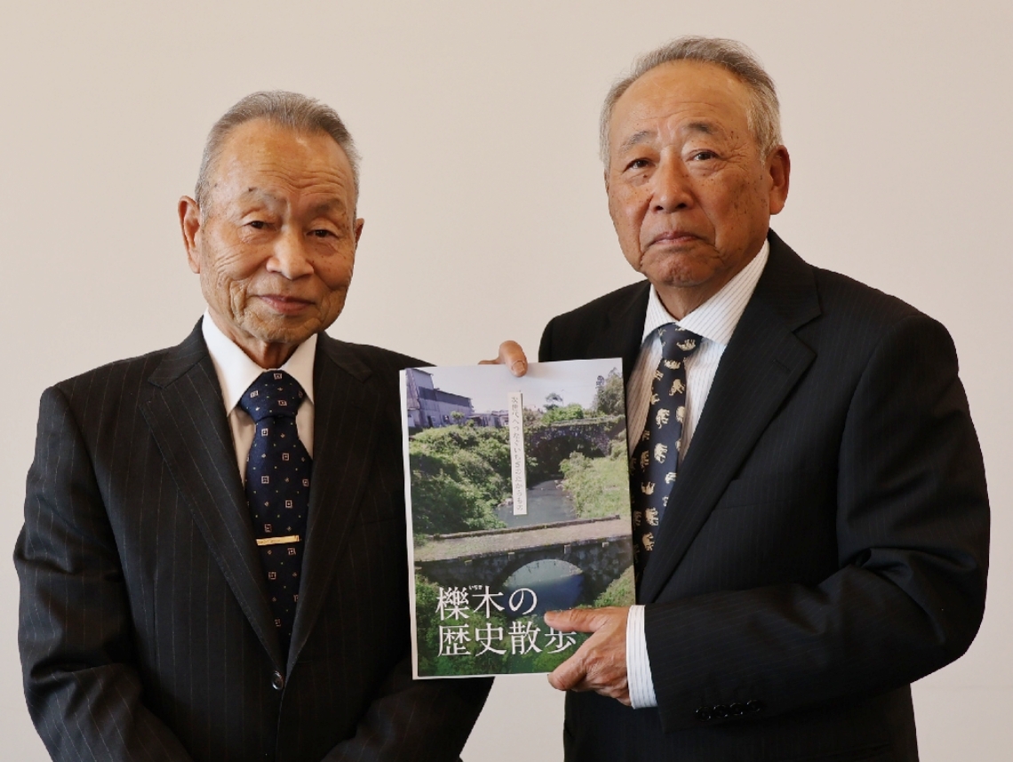 冊子を制作した「尾谷の車橋を守る会」の日野正富会長（右）と監修した日野鶴喜さん＝由布市庄内町