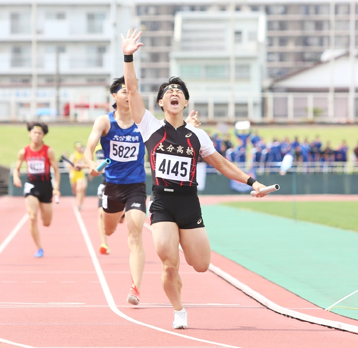 【男子１６００メートルリレー決勝】右手を突き上げて５冠の喜びを表す大分の冨田（手前）＝ジェイリーススタジアム