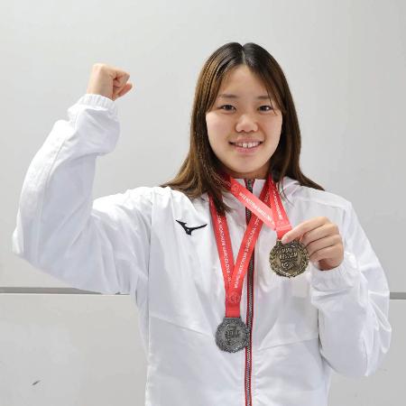 メダルを手にポーズをとる競泳女子の平井瑞希＝２７日、成田空港