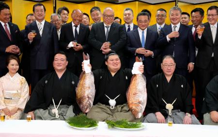 横綱昇進の伝達式後、タイを手に笑顔を見せる大の里。左隣は二所ノ関親方＝２８日午前、茨城県阿見町の二所ノ関部屋