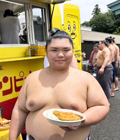 大の里が用意した「チャンピオンカレー」を手にする二所ノ関部屋の谷口＝２９日、茨城県阿見町