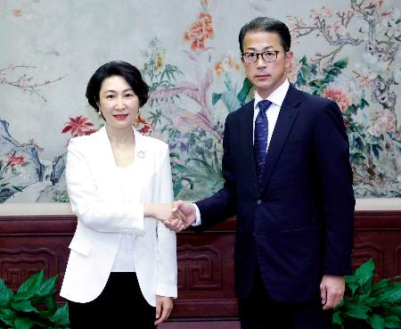 握手する日本外務省の北村俊博外務報道官（右）と中国外務省の毛寧報道局長（毛寧氏のＸから、共同）