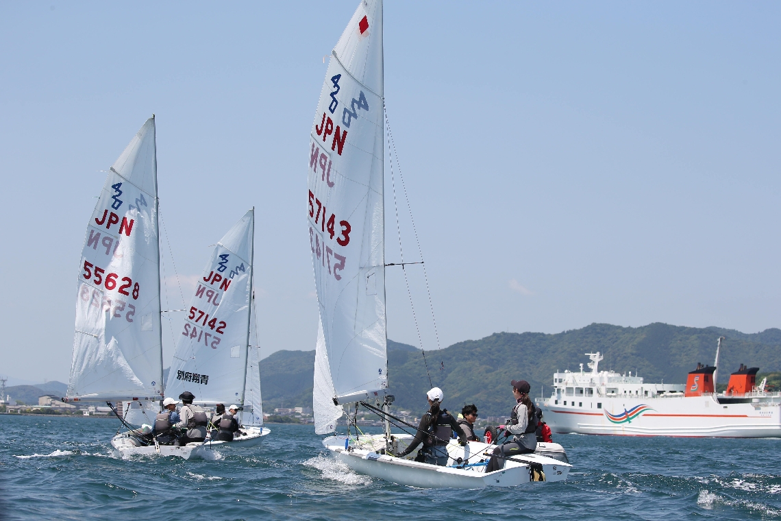 スタート前、フェリー（右端）と擦れ違うヨットの選手たち＝臼杵湾