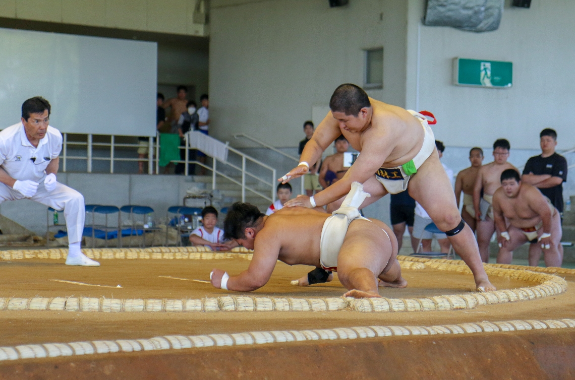 【相撲団体・日田林工―中津東】突き落としで勝利した日田林工の中堅・野口（右）＝宇佐市総合運動場相撲場