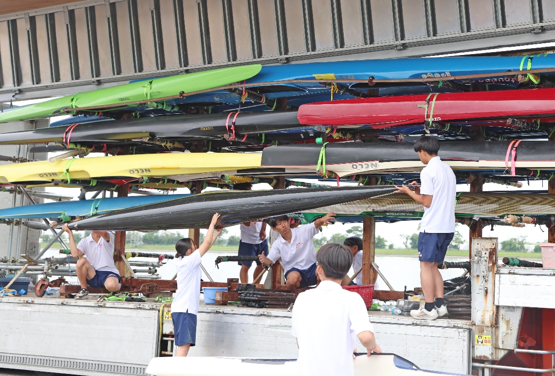 競技用カヌーを運ぶ選手たち