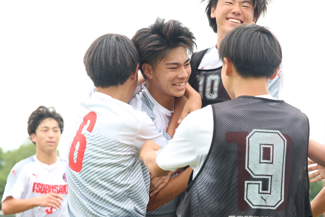 後半３３分、３点目のゴールを決めて喜ぶ鶴崎の吉元（中央）を祝福する仲間たち