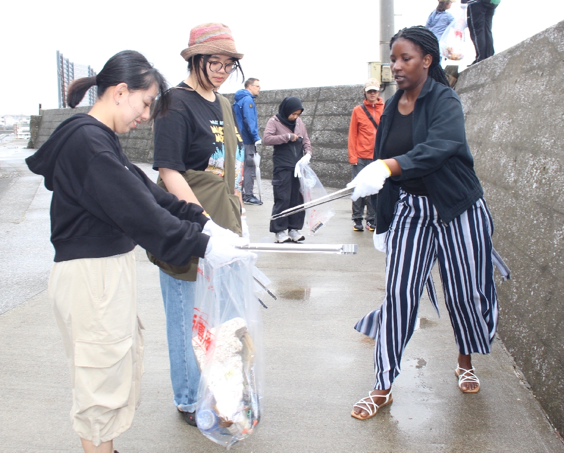 路上のごみを拾う学生＝津久見市保戸島
