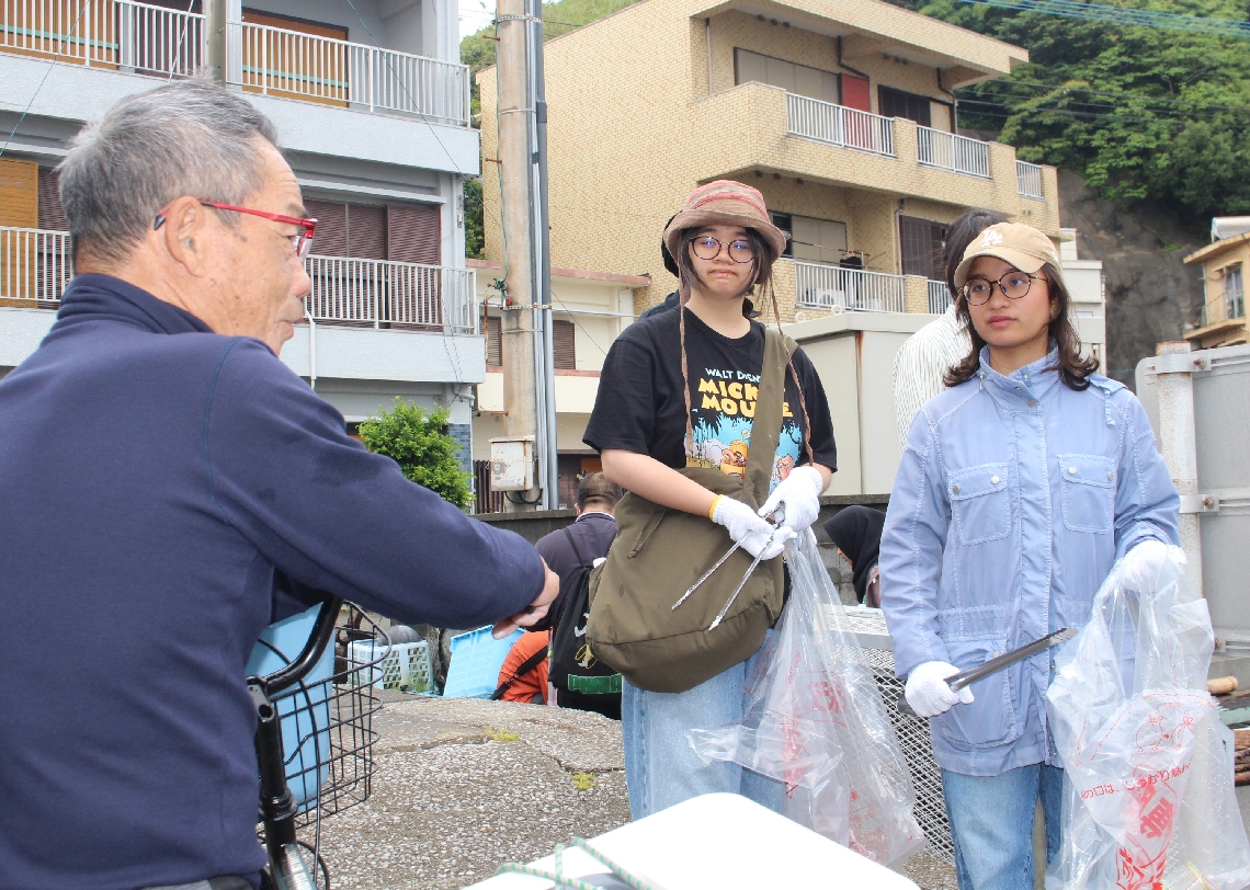 ごみ問題について島民にインタビューする学生