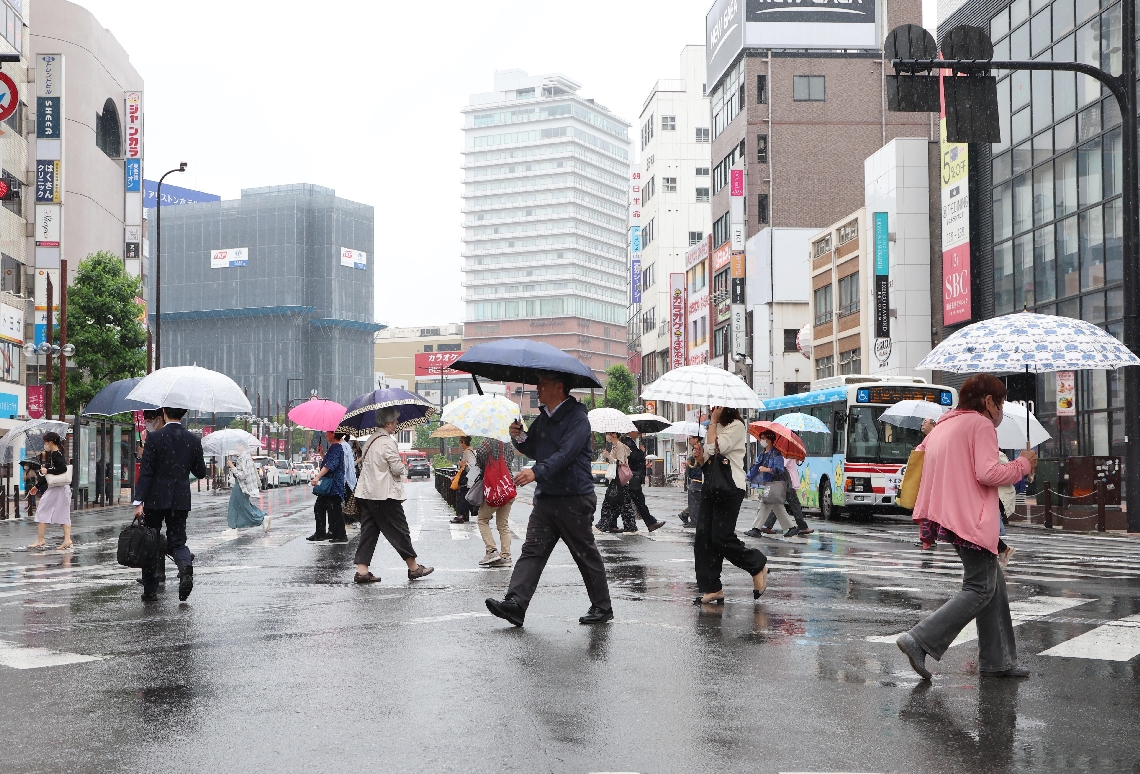 傘を差して歩く人たち＝９日、大分市の中央通り