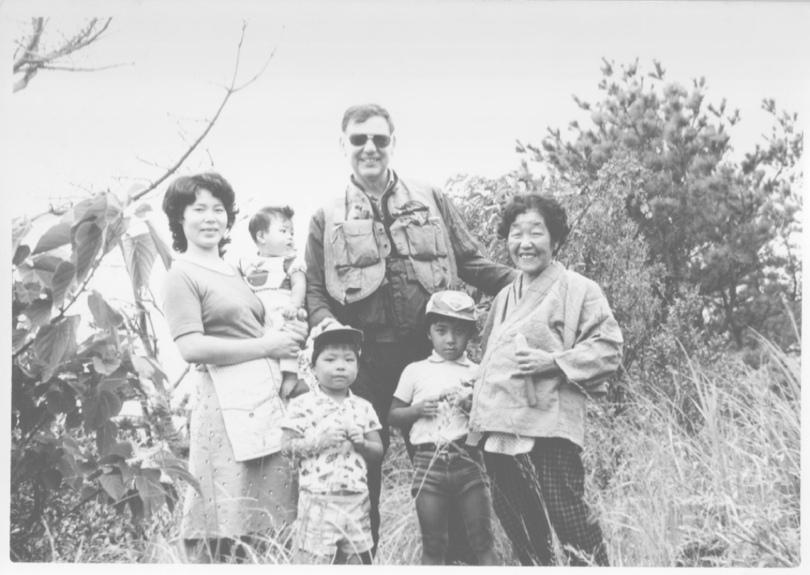 仙崎砲台跡で出会った家族連れと写真に納まるデビッド・カーチナーさん（中央）＝１９７０年代、佐伯市蒲江西野浦