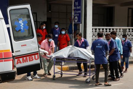 １３日、インド西部アーメダバードで旅客機の墜落事故の犠牲者を運ぶ医療従事者ら（ロイター＝共同）