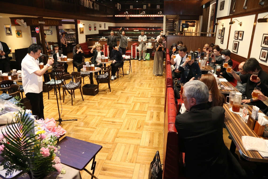 ナナママをしのぶ会で献杯する参列者たち