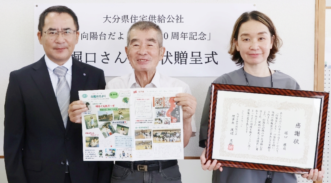 「向陽台だより」の発行を続けている堀口厚さん（中央）と渡辺文雄理事長（左）、岡田雅子さん＝国東市武蔵町