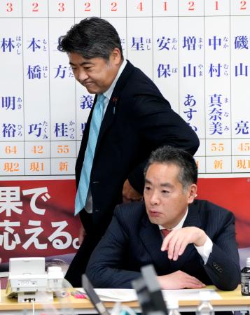 東京都議選の開票が進む中、席を立つ自民党の木原選対委員長。手前は東京都連の井上会長＝２２日深夜、永田町の党本部