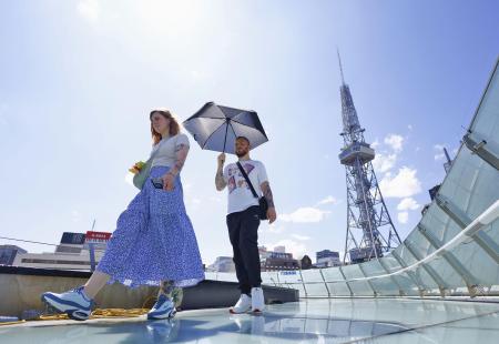 強い日差しの中、名古屋市内を歩く観光客＝６月１７日