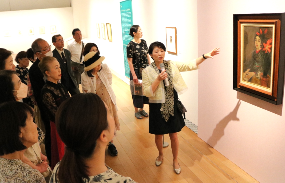 「アマリリス」について説明する夢二郷土美術館の小嶋ひろみ館長代理（右端）＝６日、大分市寿町の県立美術館