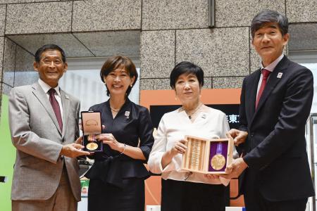 陸上世界選手権の東京開催２大会のメダルを手に写真に納まる日本陸連の有森裕子会長（中央左）と東京都の小池百合子知事（同右）ら＝６日、都庁