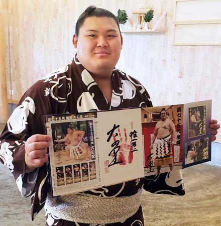 自身の横綱昇進を記念した「フレーム切手セット」を持つ大の里＝７日、愛知県安城市の二所ノ関部屋宿舎