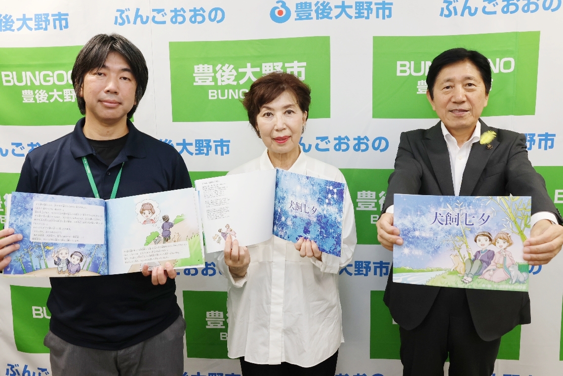自費出版した絵本を豊後大野市に寄贈した一般社団法人「わん＆わん」の宇野真理子理事長（中央）と宇野功二理事（左）＝豊後大野市役所