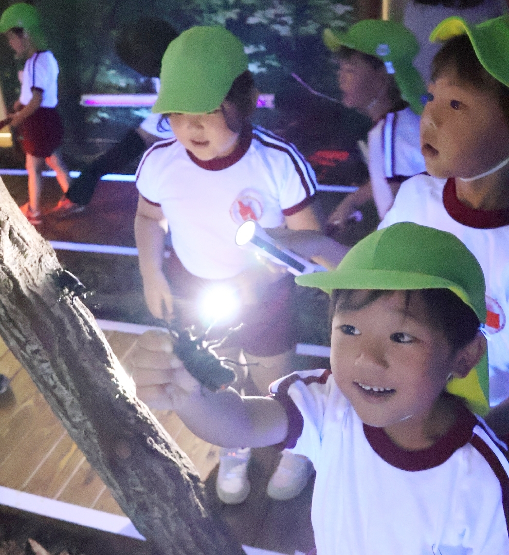 カブトムシと触れ合う園児たち＝佐伯市直川の直川憩の森公園