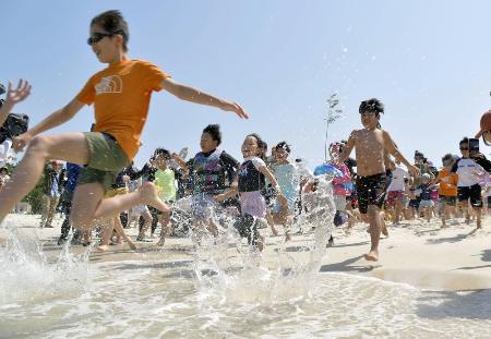 ５月、和歌山県白浜町の白良浜が海開きし、一斉に海へ駆け込む海水浴客