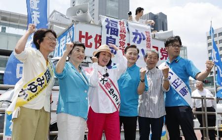 ３日、参院選が公示され、ラサール石井氏（中央右）らとポーズをとる社民党の福島瑞穂党首（左から２人目）＝東京・新宿