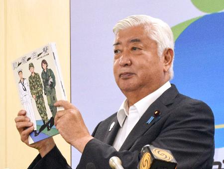 ２０２５年版防衛白書を掲げる中谷防衛相＝１５日午前、防衛省