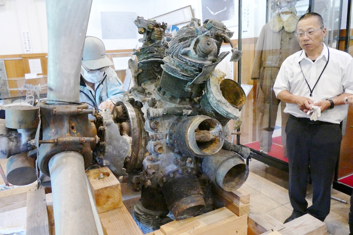 史料館「寄須処」に運び込まれたゼロ戦のエンジンとプロペラ。右は三ノ宮栄一さん