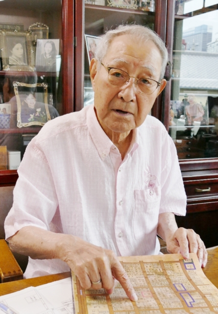 地図で当時の自宅を示す飯田哲朗さん。街は空襲で焼き払われた＝６月２４日、別府市山の手町