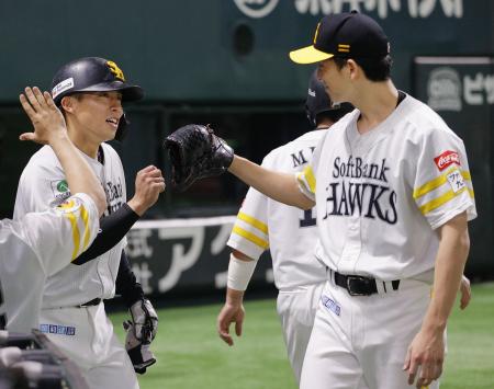 ６回、佐藤直の適時打で生還し、大関（右）とタッチを交わすソフトバンク・野村＝みずほペイペイドーム