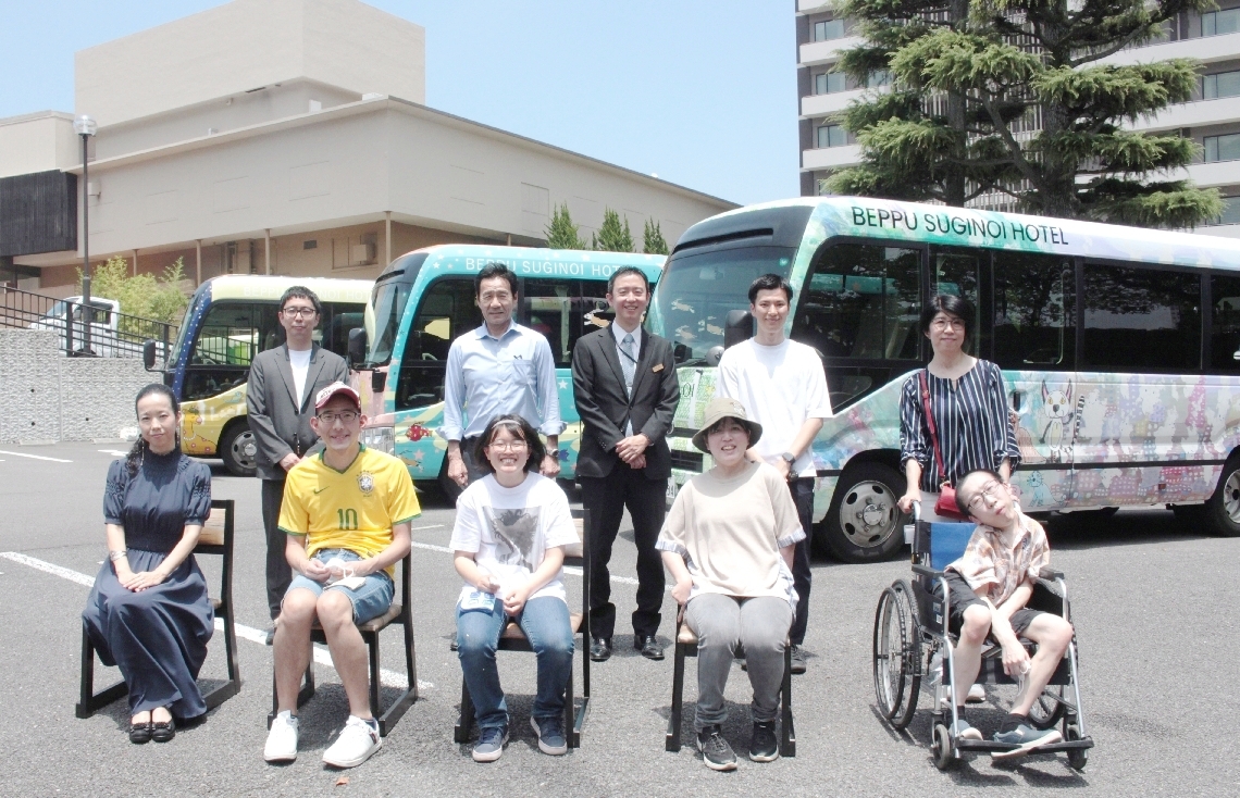 ラッピングバスをデザインしたジュンファントさん（前列左端）と「デザイナーズカンパニー　ユーツー」の利用者（前列右４人）