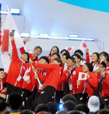 世界ユニバーシティー夏季大会の開会式で、行進中に写真撮影をする日本選手団＝デュイスブルク（共同）