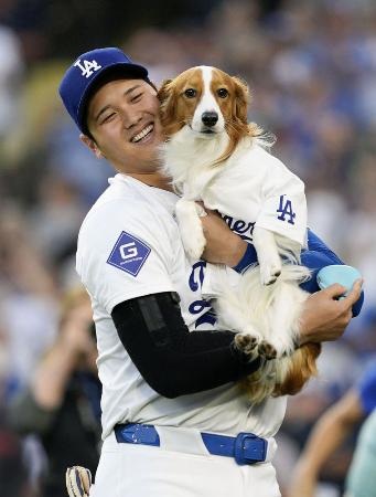 昨年８月、米大リーグのオリオールズ戦で「始球式」を行った愛犬デコピンと笑顔のドジャース・大谷翔平＝ロサンゼルス