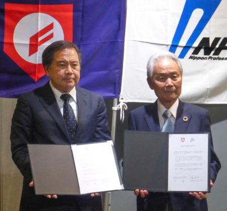 合意書を手にする日本高野連の宝馨会長（左）と日本野球機構の榊原定征コミッショナー＝１８日午後、東京都文京区