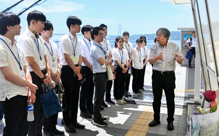 事故現場の歩道橋で、明石市の新人職員に説明する遺族の下村誠治さん（右端）＝１８日午前、兵庫県明石市